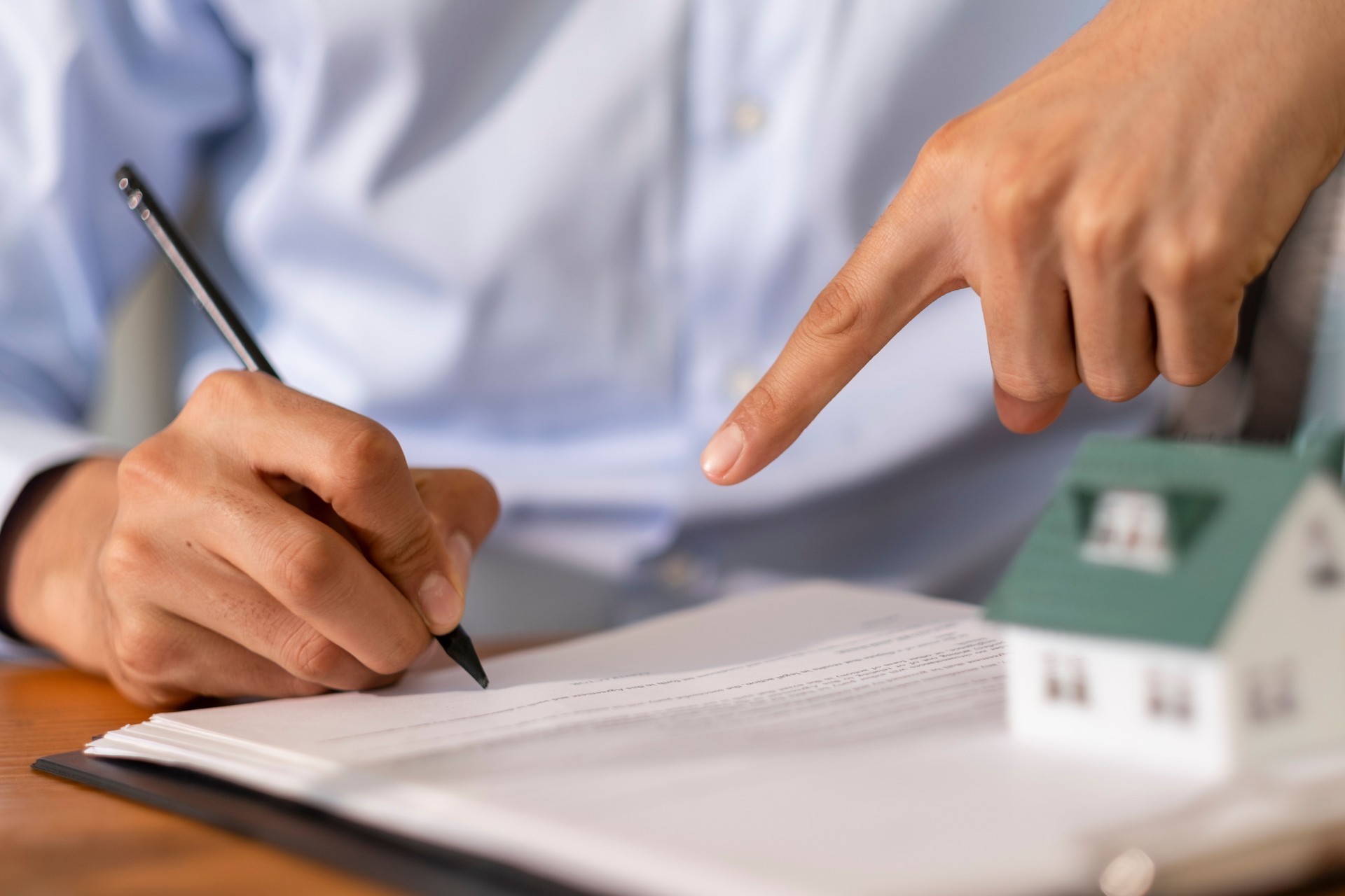 Real estate agent showing where to sign a contract for a new house purchase agreement