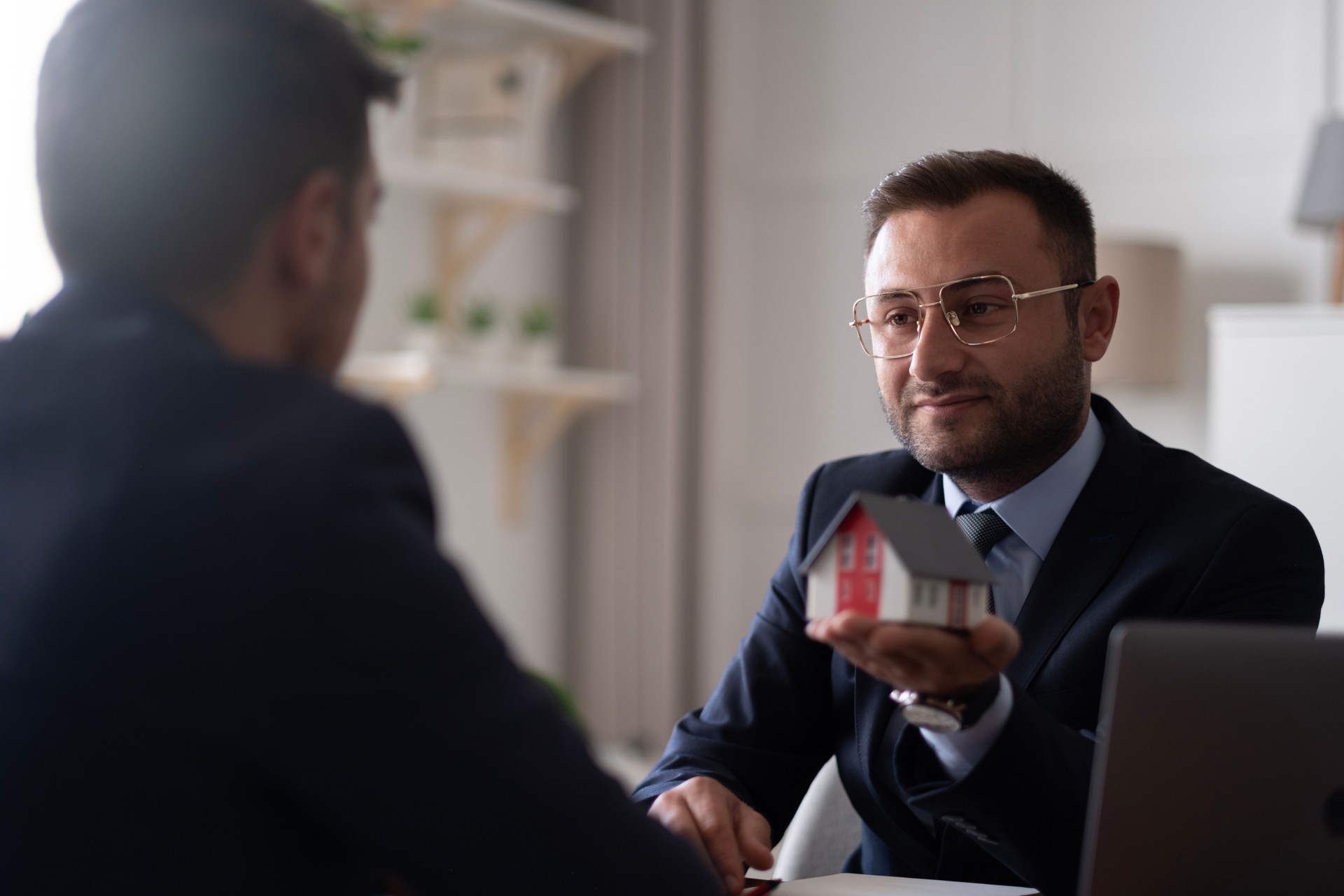 Estate agent shaking hands with his customer after contract signature